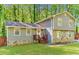 Charming two-story home featuring stone accents and gray siding nestled among lush greenery and a well-manicured lawn at 484 Aberdeen Dr, Stonecrest, GA 30083