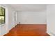 Bright living room featuring wood floors, large windows with sheer curtains, and freshly painted white walls at 484 Aberdeen Dr, Stonecrest, GA 30083