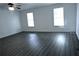 Large living room with gray wood-look flooring, ceiling fan and two large windows at 110 Ridge Se Ct, Mableton, GA 30126