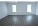 Open living room with gray wood-look flooring and large windows at 110 Ridge Se Ct, Mableton, GA 30126