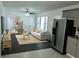 Bright living room and kitchen combo with hardwood flooring, ceiling fan, stainless refrigerator, and lots of natural light at 110 Ridge Se Ct, Mableton, GA 30126