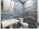 Elegant powder room with pedestal sink, elongated toilet, and unique blue woodgrain tile accent wall at 2002 Cedar Chase Ne Ln, Atlanta, GA 30324