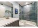 Bright bathroom featuring modern vanity, tub with glass door and decorative tiling at 2002 Cedar Chase Ne Ln, Atlanta, GA 30324