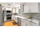 Renovated kitchen with stainless steel appliances, white cabinets, marble counters, and a mosaic backsplash for a gourmet cooking space at 2002 Cedar Chase Ne Ln, Atlanta, GA 30324