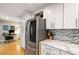 Modern kitchen showcasing stainless steel refrigerator, white cabinets, stylish backsplash, and wine rack above refrigerator at 2002 Cedar Chase Ne Ln, Atlanta, GA 30324