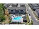 Aerial view of townhomes with a community pool, lounge chairs, umbrellas, and a pergola at 3003 Evanshire Ave, Duluth, GA 30096