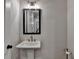 Elegant powder room featuring a pedestal sink, decorative mirror, and stylish fixtures at 3003 Evanshire Ave, Duluth, GA 30096
