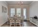 Bright dining area features a white table set, stylish chandelier, and natural light from nearby windows at 3003 Evanshire Ave, Duluth, GA 30096