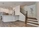 Welcoming entryway featuring stairs and a view of the modern kitchen with white cabinets and stainless steel appliances at 3003 Evanshire Ave, Duluth, GA 30096
