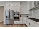 Modern kitchen features stainless steel appliances, white cabinetry, and a sleek cooktop at 3003 Evanshire Ave, Duluth, GA 30096
