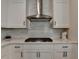 Bright kitchen with stainless vent hood, white cabinets, and white subway tile backsplash at 3003 Evanshire Ave, Duluth, GA 30096