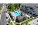 Aerial view of a community pool with lounge chairs and umbrellas next to townhomes and mature trees at 3003 Evanshire Ave, Duluth, GA 30096