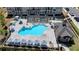 Aerial view of a community pool with lounge chairs and umbrellas and a pergola next to townhomes at 3003 Evanshire Ave, Duluth, GA 30096