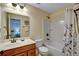 Neutral bathroom with a shower and tub combination, vanity, mirror, and a floral shower curtain at 3215 Trowbridge Dr, Cumming, GA 30040