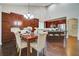 Bright dining area features wood floors, granite counters, and ample seating at the table and island at 3215 Trowbridge Dr, Cumming, GA 30040