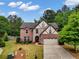 Charming two-story brick home with stone accents, a two-car garage, and lush green lawn at 3215 Trowbridge Dr, Cumming, GA 30040