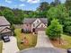 Aerial view of a two-story brick home with a two-car garage and lush landscaping at 3215 Trowbridge Dr, Cumming, GA 30040