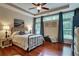 Comfortable main bedroom with a tray ceiling, a ceiling fan, hardwood floors, and natural light at 3215 Trowbridge Dr, Cumming, GA 30040