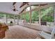 Enclosed sunroom surrounded by windows offers backyard views, ceiling fans, and neutral brick flooring at 3215 Trowbridge Dr, Cumming, GA 30040