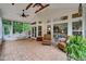 Cozy sunroom with ample sunlight features brick flooring, ceiling fans, and backyard views at 3215 Trowbridge Dr, Cumming, GA 30040