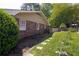 View of the brick exterior wall and partial backyard showcasing stepping stones and a wooden fence at 4350 Bonaparte Dr, Tucker, GA 30084