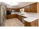 Traditional eat-in kitchen features wood cabinetry, stainless steel appliances, and tile flooring at 4350 Bonaparte Dr, Tucker, GA 30084