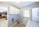 Laundry room with overhead cabinets, tile floor, washer hookups, and access to the backyard at 4350 Bonaparte Dr, Tucker, GA 30084