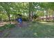 Backyard playground with slide and climbing structure surrounded by mature trees and landscaping at 4350 Bonaparte Dr, Tucker, GA 30084