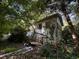 Back exterior view of home, with trees, and items scattered about at 1164 Oldfield Rd, Decatur, GA 30030