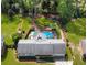 Aerial view of a home's backyard featuring a pool, play set, and mature trees creating a private oasis at 1834 Kimberly Sw Dr, Marietta, GA 30008