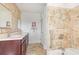 Well-lit bathroom with a double sink vanity, decorative tile and shower with grab bar at 1834 Kimberly Sw Dr, Marietta, GA 30008