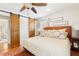 Bedroom features a bed, ceiling fan, barn door, and light-filled windows at 1834 Kimberly Sw Dr, Marietta, GA 30008