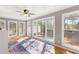 Bright sunroom featuring hardwood floors, lots of windows, a ceiling fan and a colorful area rug at 1834 Kimberly Sw Dr, Marietta, GA 30008