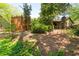 This backyard includes a patio with fireplace, wooden privacy screens, lush trees, and beautiful landscaping at 4030 Muirfield Ln, Marietta, GA 30068