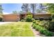 Charming single-Gathering home with a lush green lawn, attached garage, and mature trees in the background at 4030 Muirfield Ln, Marietta, GA 30068