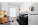 Bright laundry room with modern washer/dryer units, white cabinets, and ample counter space at 4030 Muirfield Ln, Marietta, GA 30068