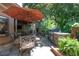 Outdoor kitchen with stainless steel gas grill, dining table, patio, and a lush backyard at 4030 Muirfield Ln, Marietta, GA 30068