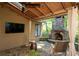 Covered patio area with stone fireplace, TV, and seating perfect for entertaining at 4030 Muirfield Ln, Marietta, GA 30068