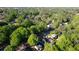 A wide aerial view of the neighborhood with lush greenery and the rooftops of nearby homes and the street at 4157 Town Branch Ct Sw, Covington, GA 30014