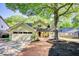 Charming home featuring a brick walkway, mature trees, a front porch with seating, and an attached garage at 4157 Town Branch Ct Sw, Covington, GA 30014