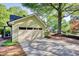 Charming home featuring a brick walkway, mature trees, and an attached garage with room for multiple cars at 4157 Town Branch Ct Sw, Covington, GA 30014