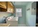 Functional laundry room with side-by-side washer and dryer units and ample cabinet space at 4157 Town Branch Ct Sw, Covington, GA 30014