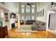 Bright living room boasts a high ceiling, wooden floor, natural light, a fireplace and comfortable gray sofa at 4157 Town Branch Ct Sw, Covington, GA 30014