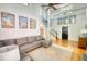 Bright living room boasts a high ceiling, wooden floor, natural light and a comfortable gray sofa at 4157 Town Branch Ct Sw, Covington, GA 30014