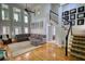 Bright living room boasts a high ceiling, wooden floor, natural light and a comfortable gray sofa at 4157 Town Branch Ct Sw, Covington, GA 30014