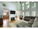Bright living room boasts a high ceiling, wooden floor, natural light, a fireplace and comfortable gray sofa at 4157 Town Branch Ct Sw, Covington, GA 30014