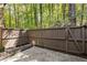 Private back patio with stone foundation, offers outdoor space bordered by trees and wooden fence at 72 Ivy Ne Pkwy, Atlanta, GA 30342