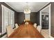 Dining room with modern light fixture and table, dark accent walls, and wood floors at 72 Ivy Ne Pkwy, Atlanta, GA 30342