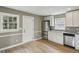 Well-lit kitchen featuring stainless steel appliances, white cabinets, and an exterior door at 1545 Orlando Sw St, Atlanta, GA 30311