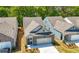 Aerial view of a brick home with attached garage, nestled among other homes and lush trees at 2617 Cacao Sq, Acworth, GA 30101